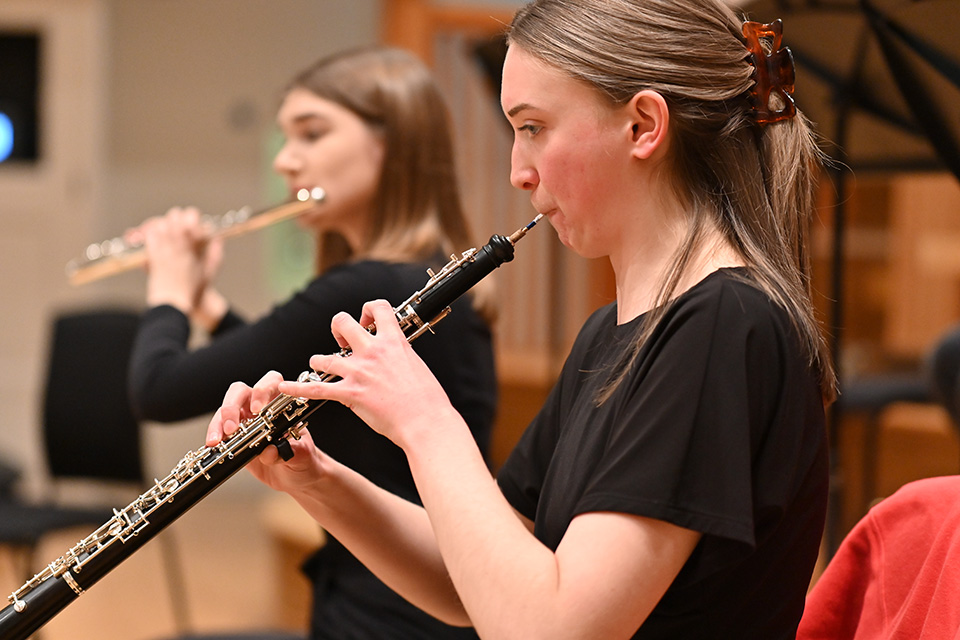 Woodwind students playing oboe and flute in rehearsal